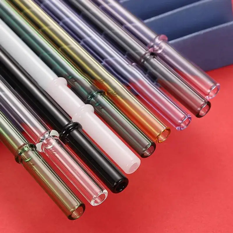 A set of colorful decorbites glass bent reusable drinking straws with transparent tubes and white and black opaque ends