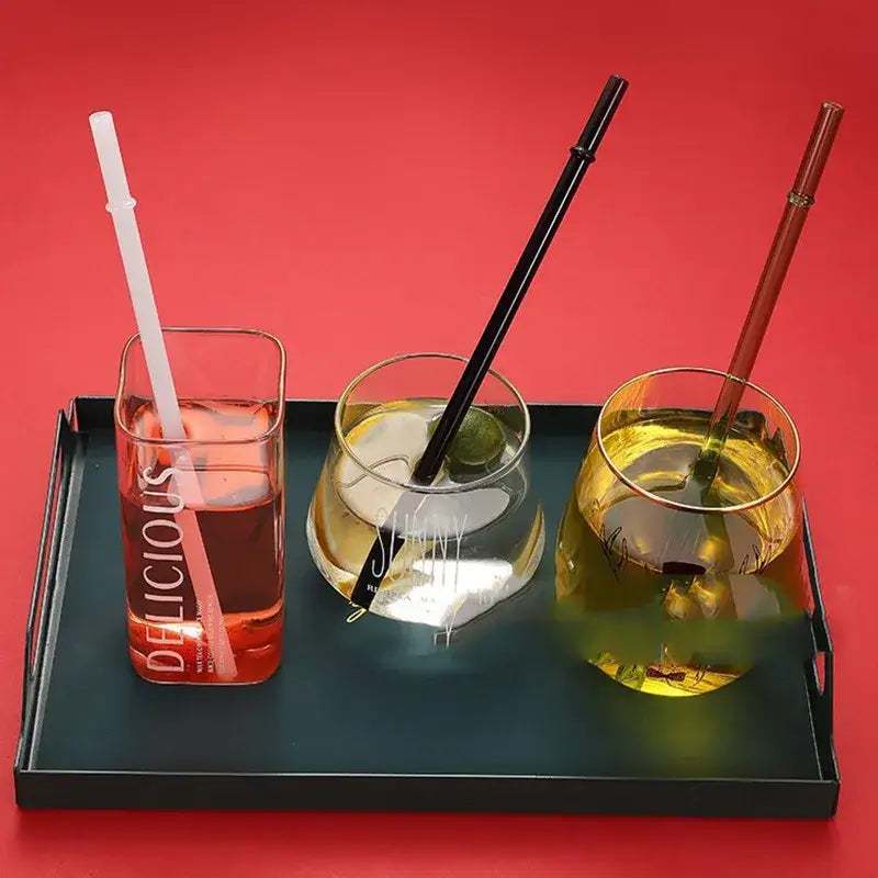 Three glass bent straws in white black and copper colors in gold rimmed clear tumblers by decorbites glass bent set