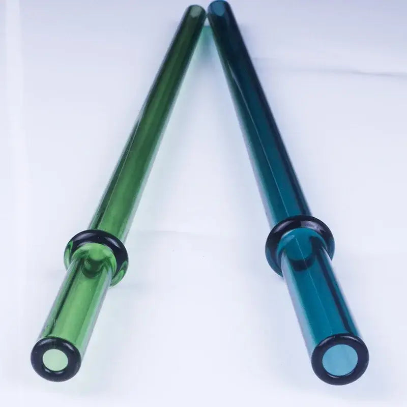 Two decorbites glass bent straws in emerald green and teal blue with black grips for reusable kitchen use