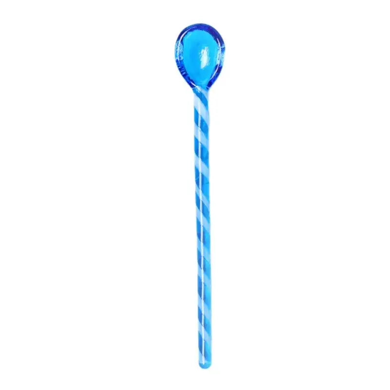 A translucent blue stirring spoon with a glossy spiral handle from decorbites colorful glass set for kitchen use