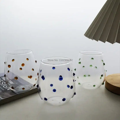 Three clear stemless wine glasses with hand-painted gold blue and green glass wave dots for dining room use