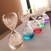 A row of clear glass decorbites bubble dream hourglass filled with swirling colorful liquid and glitter particles for kids decor