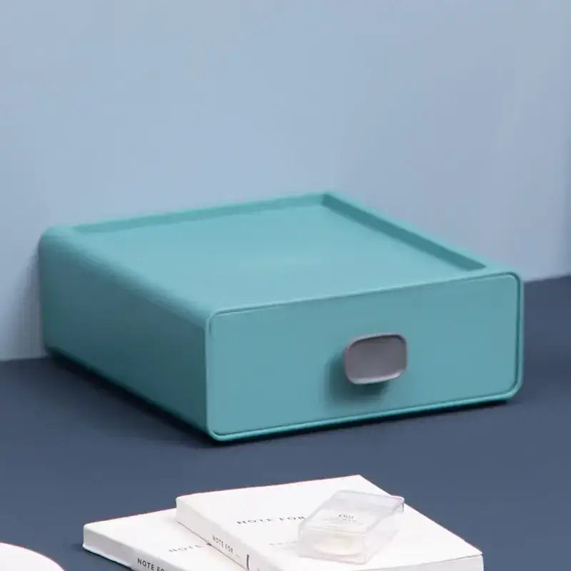 A sleek mint-green plastic desktop cosmetic storage box with matte finish and minimalist gray handle for decorbites organizer