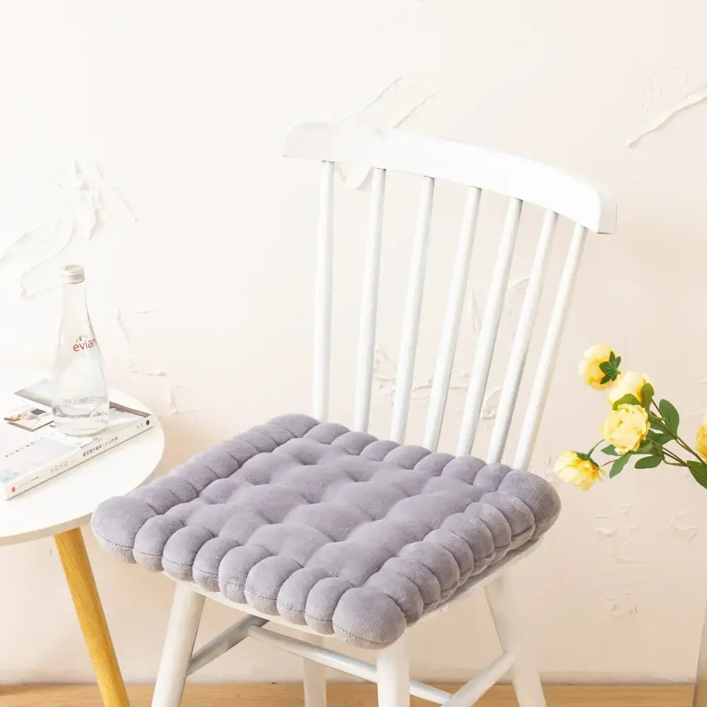 Gray quilted cookie biscuit cushion with soft plush texture and rounded tufting for living room decor