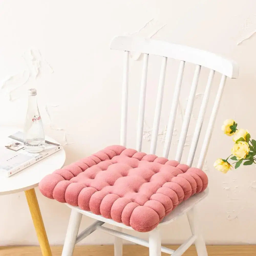 Pink tufted cookie biscuit cushion with soft plush texture and rounded button detailing for living room use