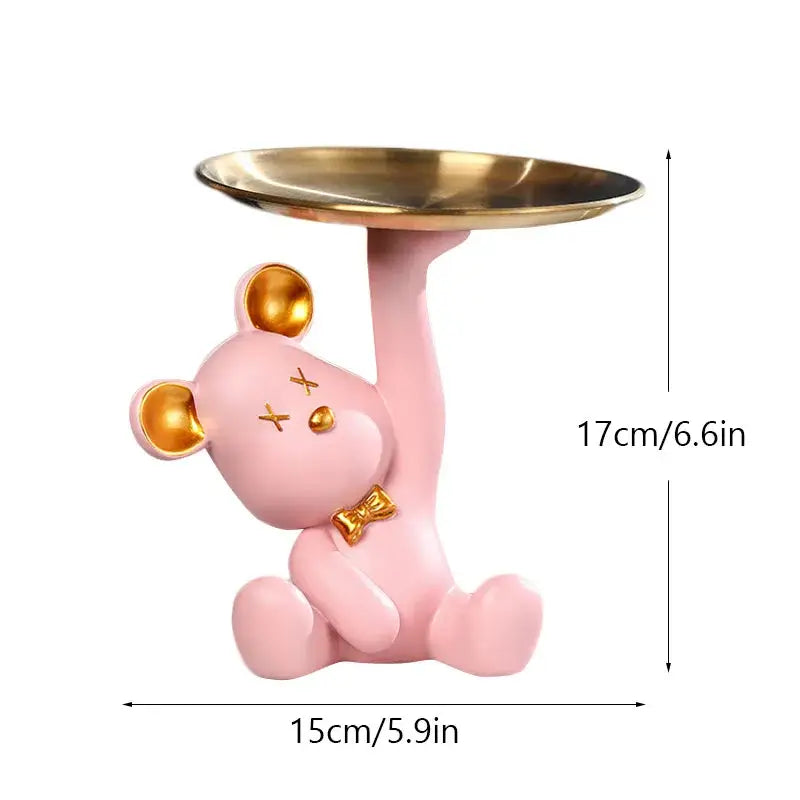 Pink resin bear house entry tray keys receiver with gold accents holding a golden tray for living room use