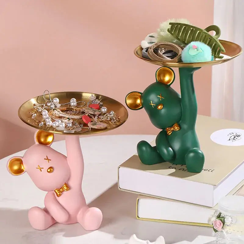 Pink resin bear house entry tray keys receiver with gold accents holding a golden tray for living room use