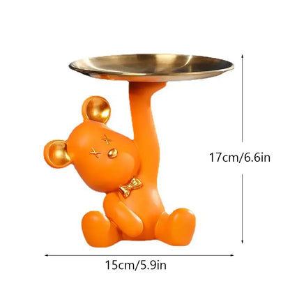 Orange resin bear house entry tray keys receiver with gold accents holding a metallic tray for living room use