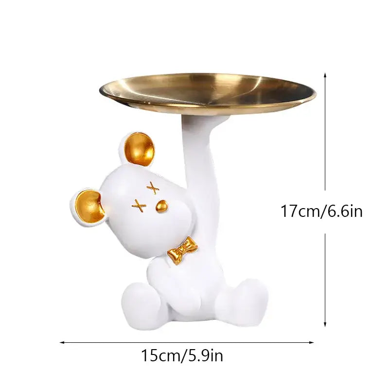 White resin bear house entry tray keys receiver with gold accents holding brass tray for living room use