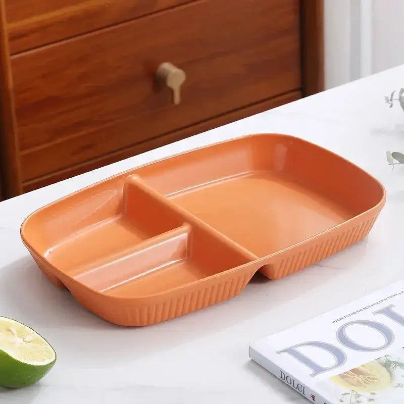 Orange plastic divided dish diet plate with three compartments and ribbed edges for dining room use