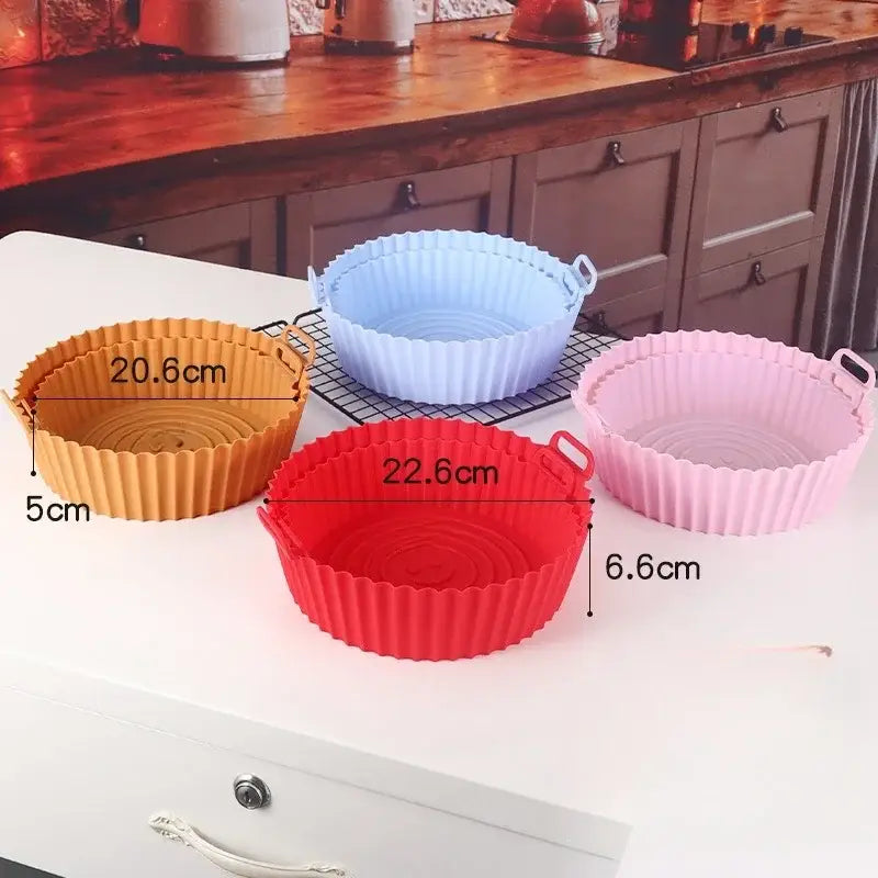 Set of four colorful silicone basket trays in orange blue red and pink with fluted edges for baking grill pan use