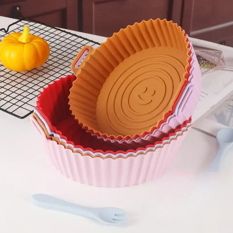 Stack of colorful silicone basket trays with a smiling face design suitable for baking grill pan use