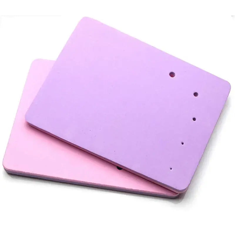 Purple and pink silicone cake shaping mat with rectangular foam earring backs and evenly spaced holes for shaping mat use