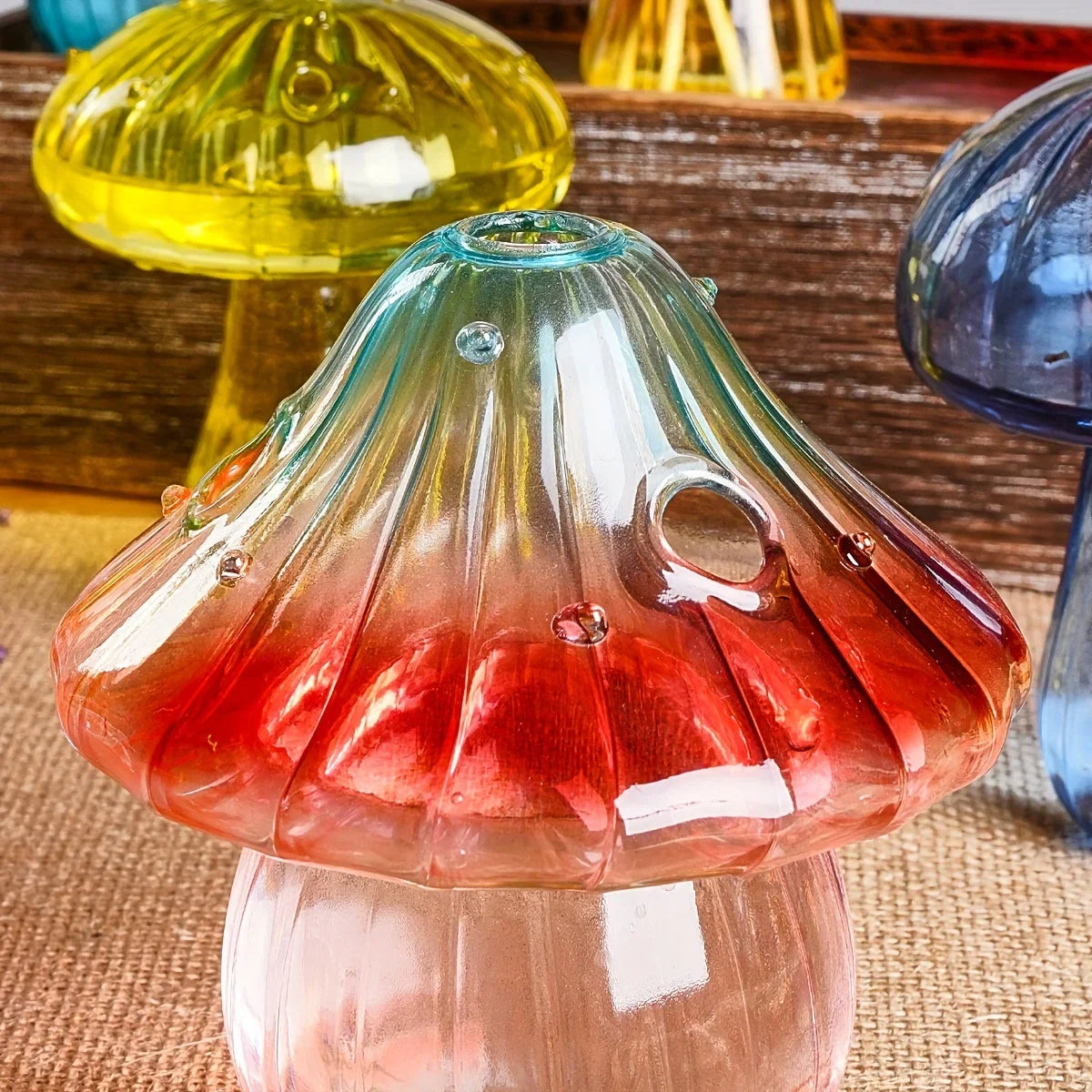 Colourful mushroom vase with red-to-teal translucent gradient glass cap and clear stem for desktop aromatherapy decor