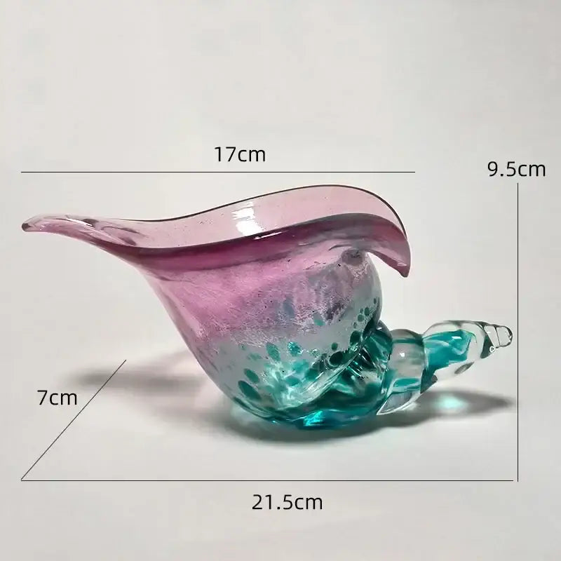 A translucent glass decorbites conch candy jar with pink and teal hues and swirling patterns for dining room storage