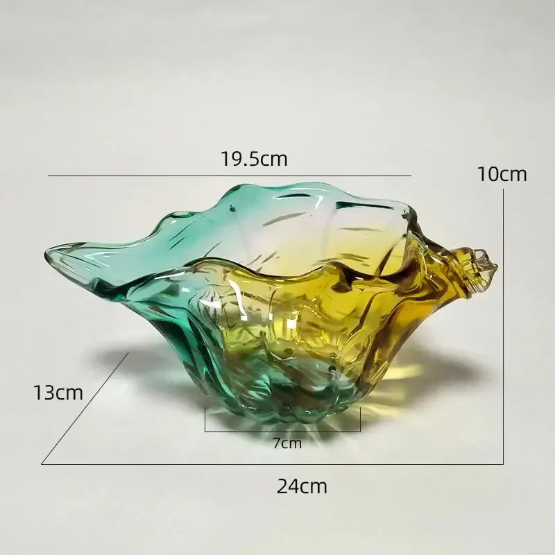 A decorbites conch candy jar made of translucent glass with green to amber gradient shaped like a seashell tray