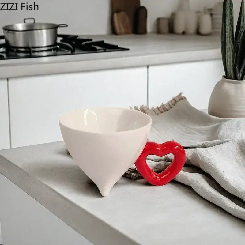 A glossy white conical ceramic coffee mug with a heart ceramic red handle for decorbites heart ceramic collection