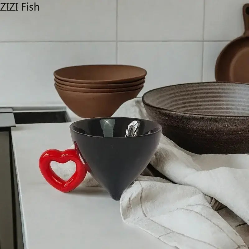 A sleek black ceramic coffee mug with a glossy finish and a vibrant red heart ceramic handle for decorbites heart ceramic use