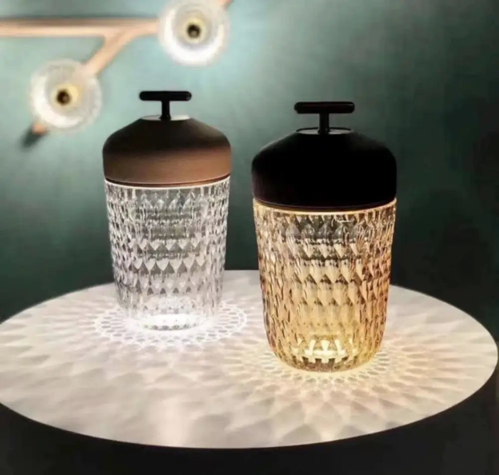 Two elegant faceted glass decorbites conical crystal bedside lamps with metallic lids emitting warm glow for bedroom atmosphere