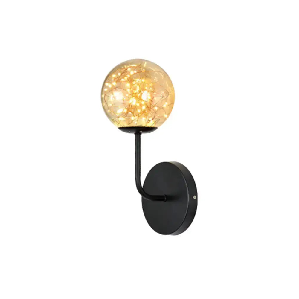 Contemporary black metal wall sconce with amber glass globe and direct wired electric filament light type for bedroom use