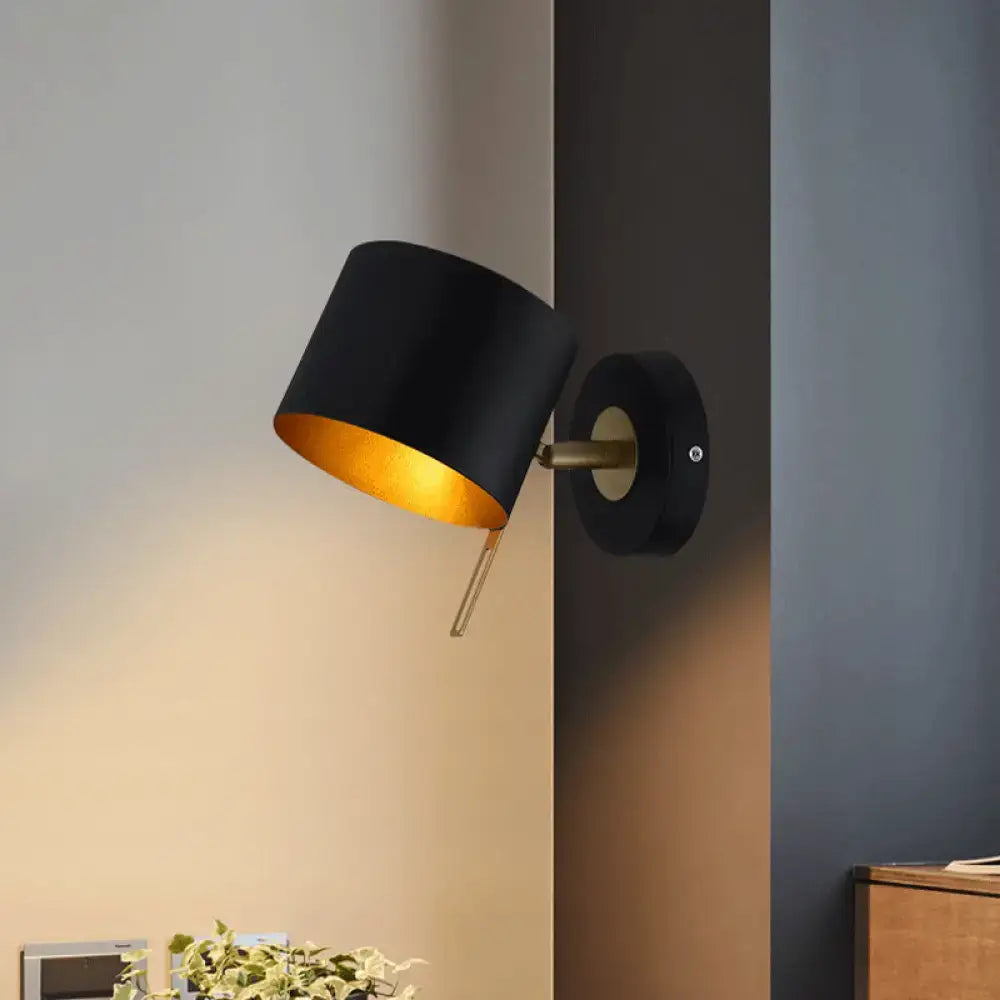 Contemporary black and gold metal drum wall sconce with brass accents for bedroom lighting