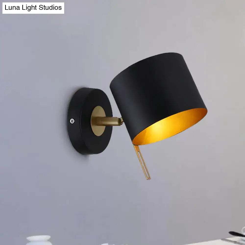 Contemporary black and gold metal drum wall sconce with brass accents for bedroom lighting