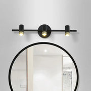 Contemporary black and brass three-light vanity light wall sconce with sleek cylindrical bulbs and adjustable color temperature