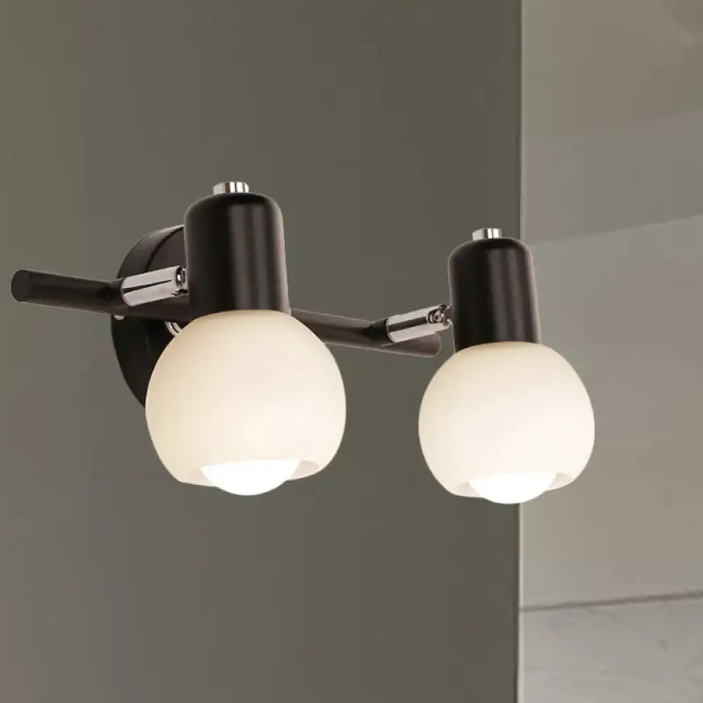 Contemporary black and chrome two-light wall sconce with milk glass frosted globe shades for living room lighting