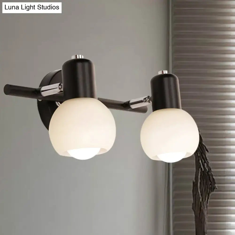 Contemporary black and chrome wall-mounted sconce with milk glass globe shades for living room lighting