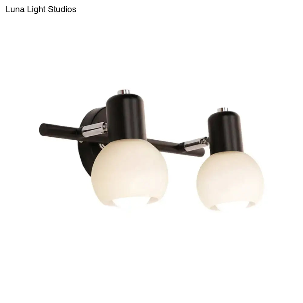 Contemporary black and chrome two-light wall sconce with frosted milk glass globe shades for living room lighting