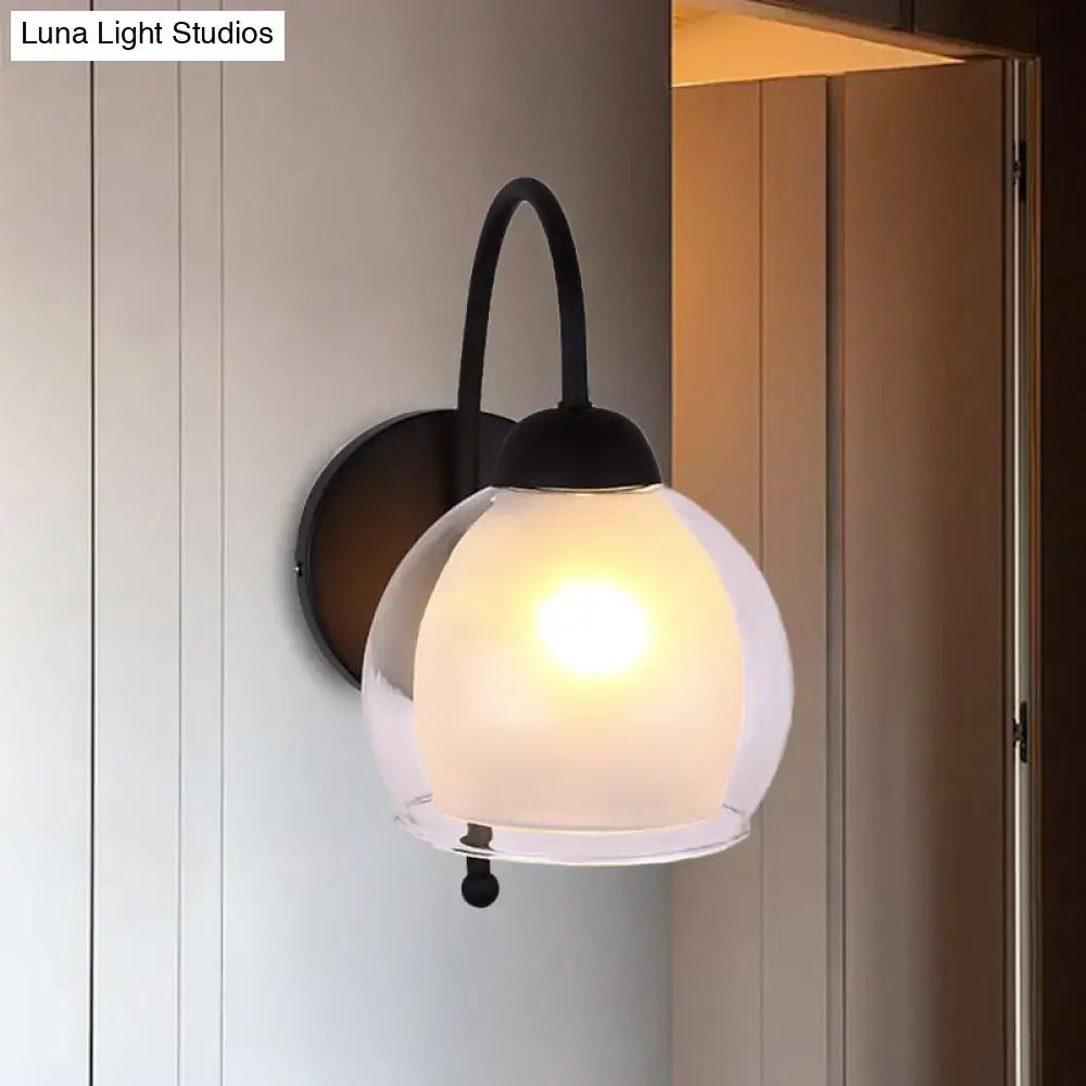Contemporary black metal wall sconce with a frosted glass globe shade for bedroom lighting