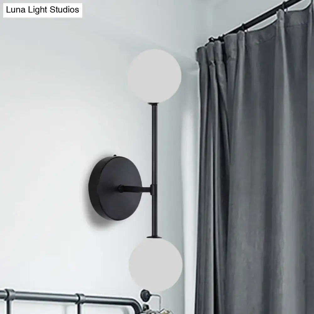 Contemporary black metal wall lamp with dual frosted glass globe shades and gold accents 12 inch fixture for bedroom