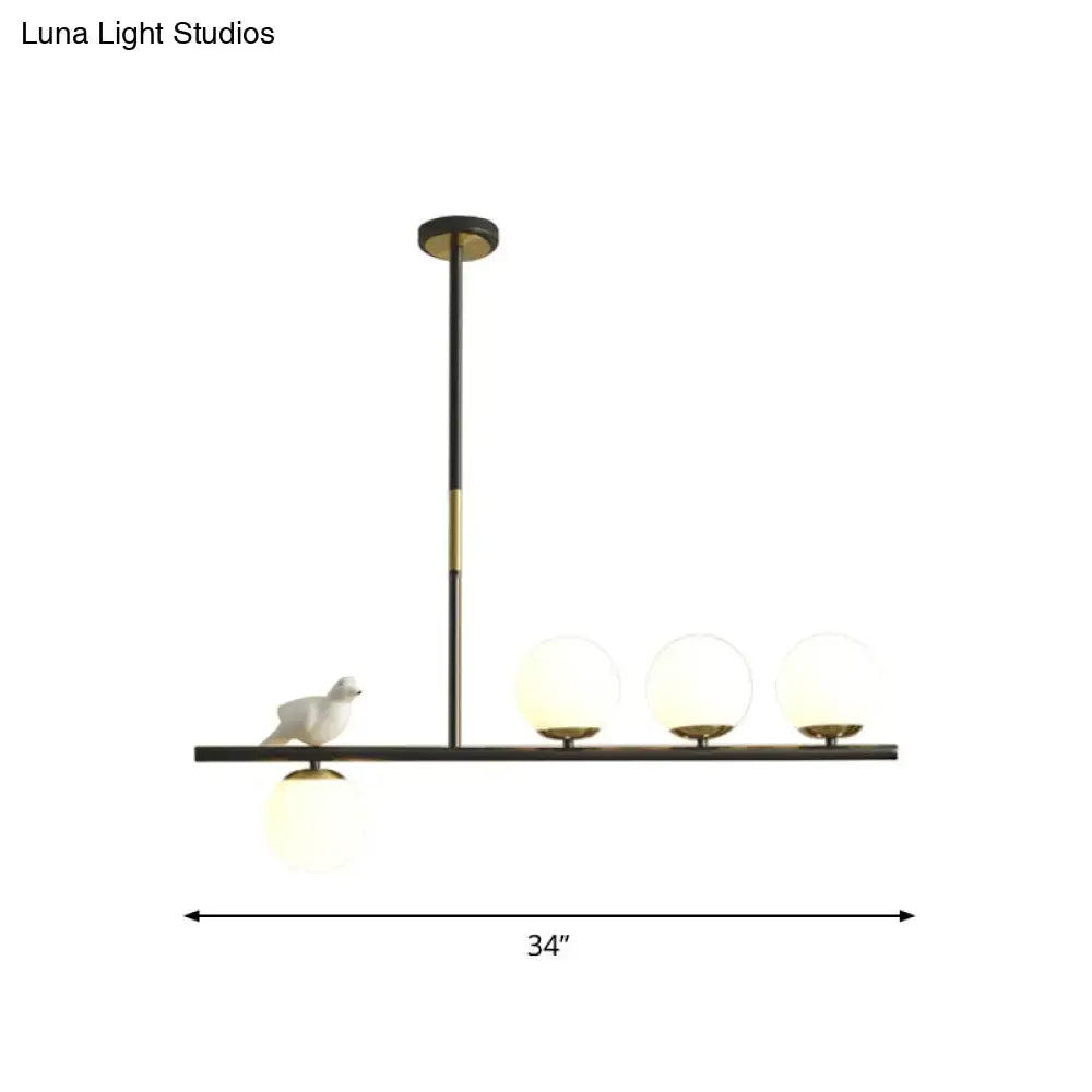 Modern black and brass decorbites linear branch dining pendant light with frosted globes and ceramic bird for dining room island