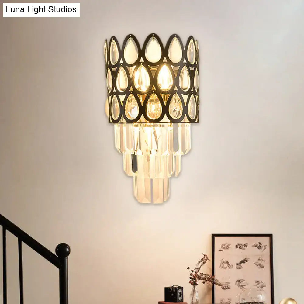 Elegant black gold sconce with cascading clear teardrop crystals and a grid wall mount for living room lighting