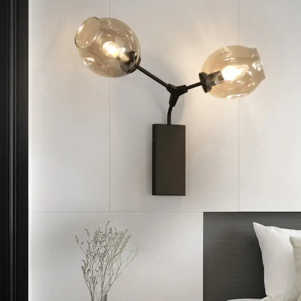Contemporary black and gold wall sconce with matte black arms and clear glass shade for modern light wall decor
