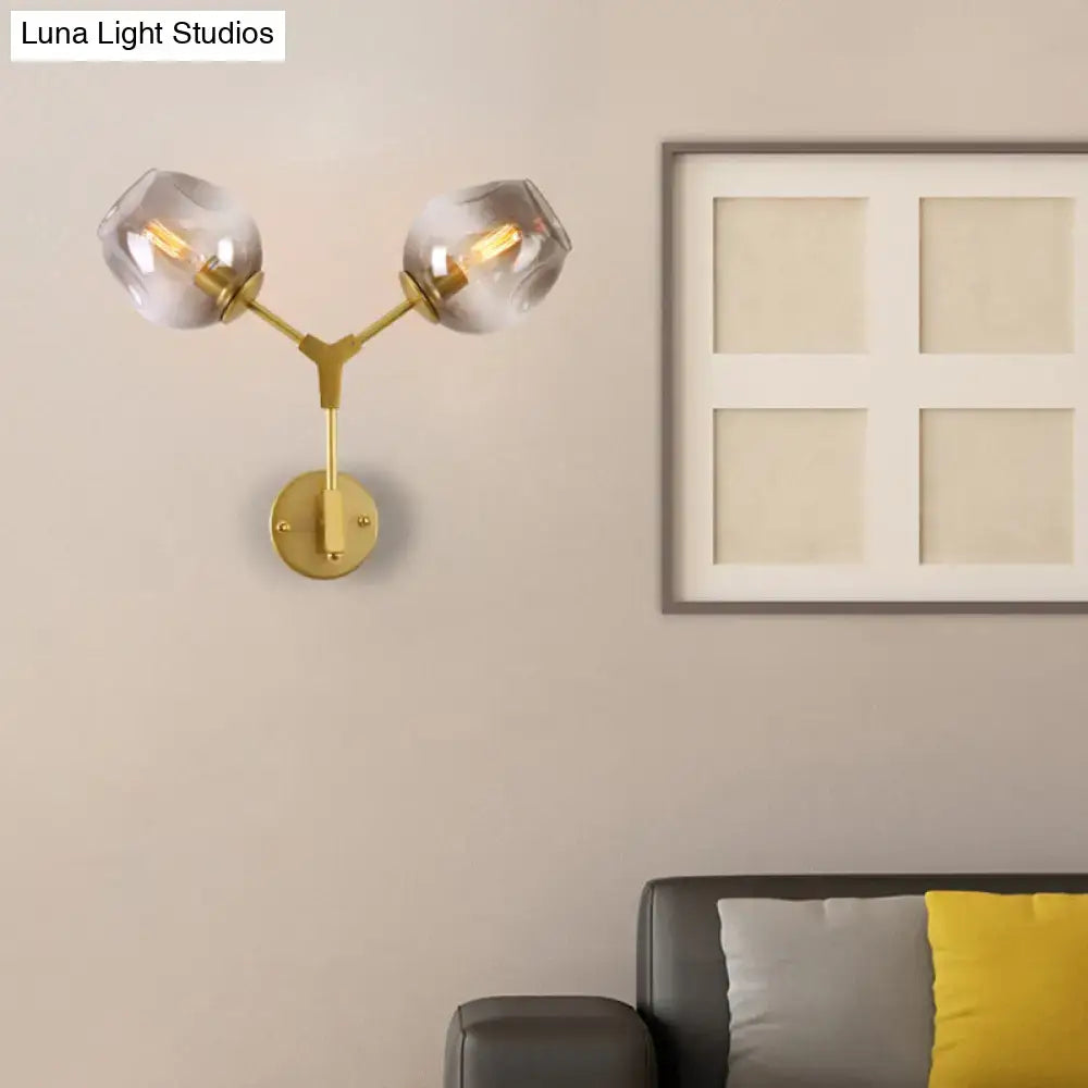 Contemporary black and gold wall sconce with gold-toned frame and two clear glass shade globes for light wall decor
