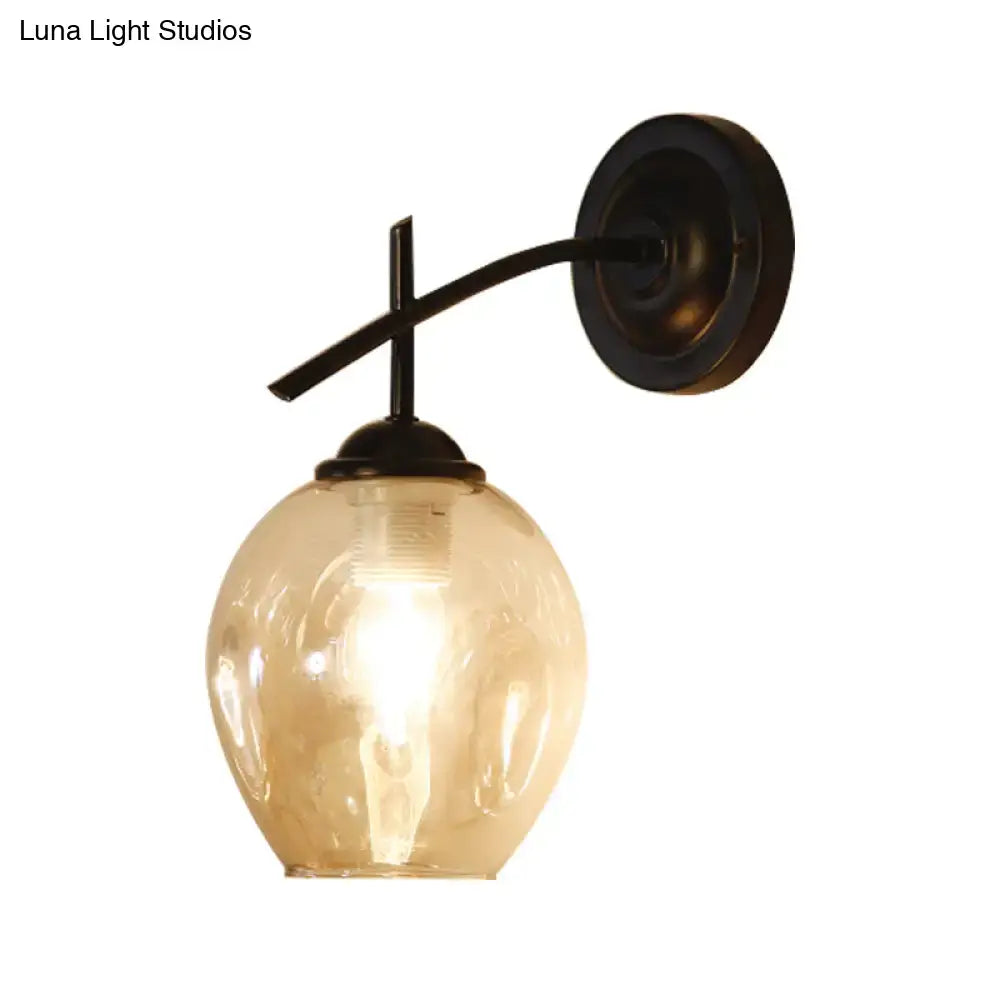 Contemporary wall sconce with dark bronze arm and warm-toned amber glass globe clear glass shade for bedroom light wall