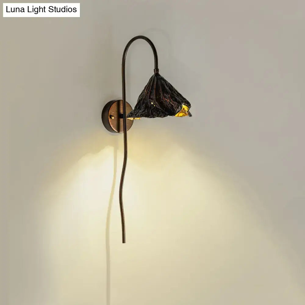 Contemporary black lotus leaf wall light with textured design gold-leaf accents and curved metal arm for living room use