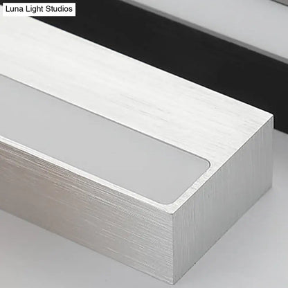 Contemporary black and silver linear vanity sconce with silver brushed aluminum and frosted glass panel for white warm light