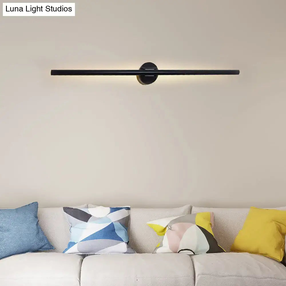Contemporary black minimalist wall light with sleek cylindrical design and warm natural light for bedroom use