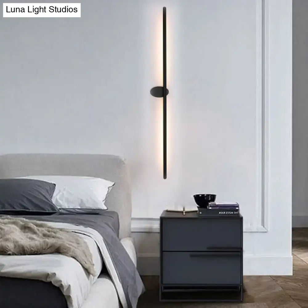 Contemporary black slim wall light with sleek vertical design providing warm natural light for bedroom ambiance