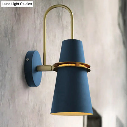 Contemporary blue and gold flared wall sconce light with brass accents and curved arm for bedroom lighting