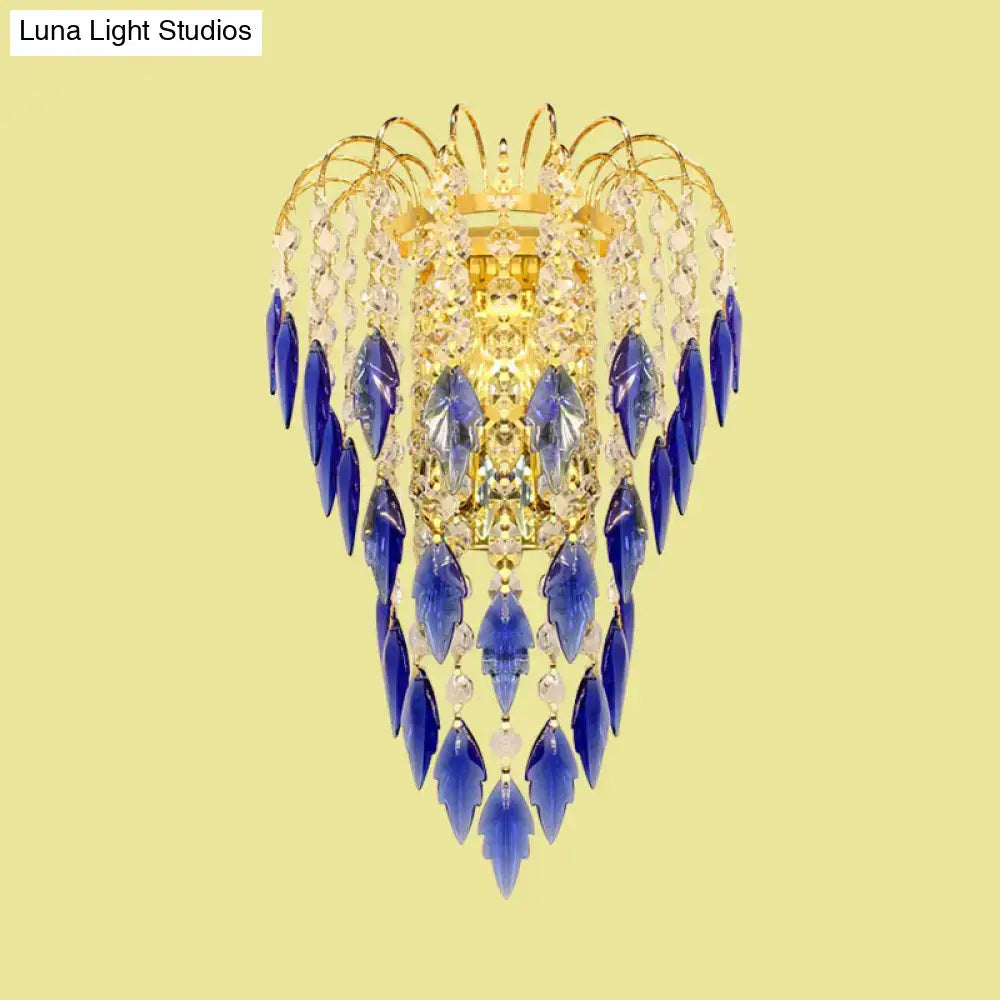 A luxurious brass wall light with amber and clear crystals featuring deep tan blue crystal droplets for extra light
