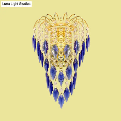 A luxurious brass wall light with amber and clear crystals featuring deep tan blue crystal droplets for extra light