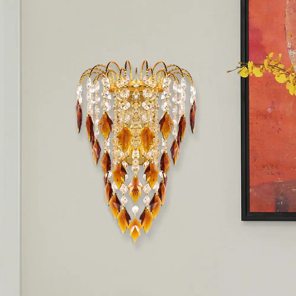 Contemporary brass wall light with gold-toned sconce and cascading amber and clear crystal leaves for extra light
