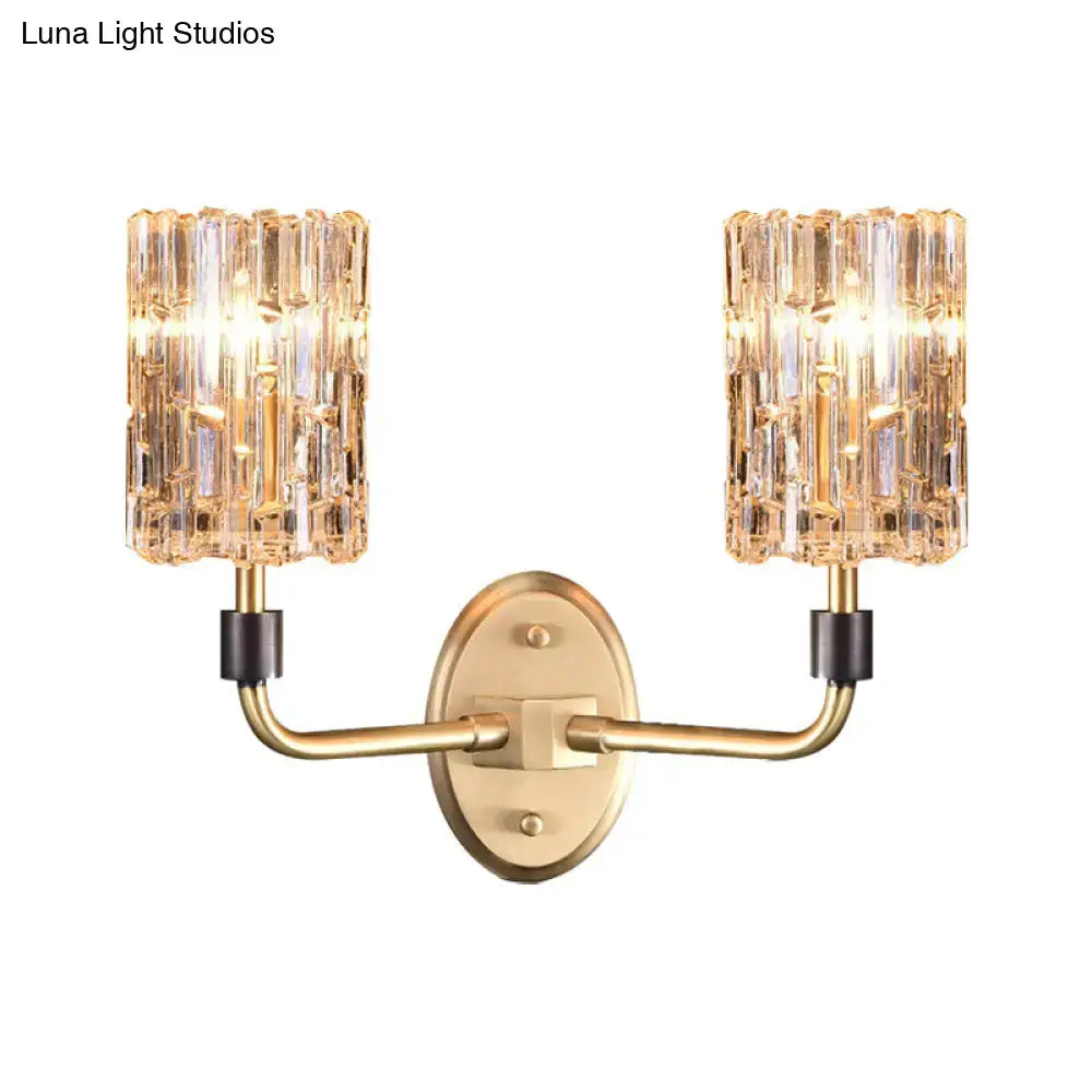 Contemporary brass bedside wall sconce with gold tone and two clear crystal shades for bedroom lighting