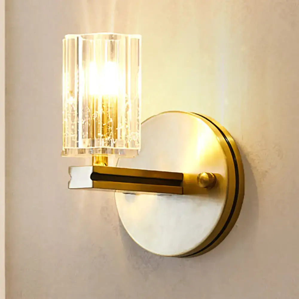 Contemporary brass crystal cylinder sconce light with gold-toned prismatic crystal cylinder shade and circular backplate
