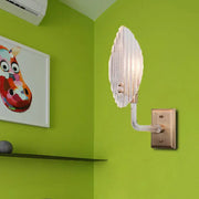 Contemporary brass leaf wall light fixture with a translucent glass sconce and brass-finished mounting plate for living room