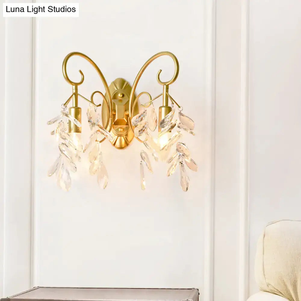 Contemporary gold-toned brass teardrop crystal wall mount light with crystal leaf accents for bedroom use