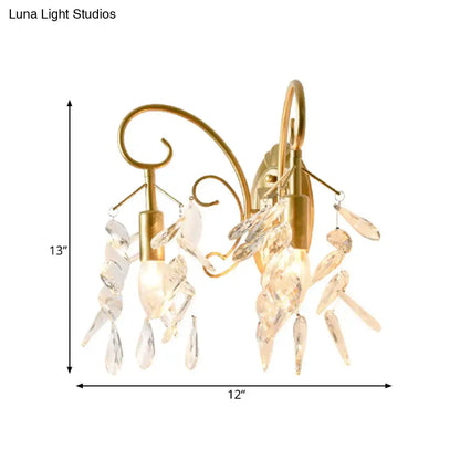 Contemporary gold-toned brass teardrop crystal wall mount light with two ornate arms for bedroom use